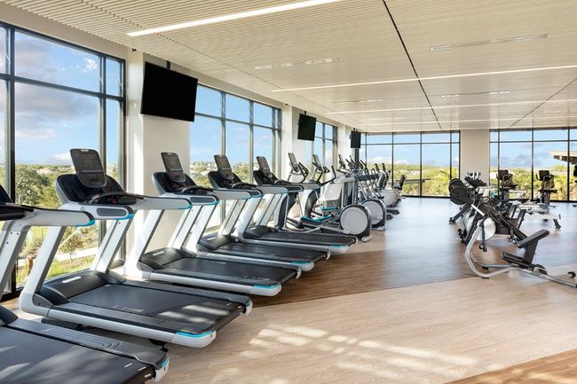 Exercise room with a wall of windows and wood finished floors | Image 5
