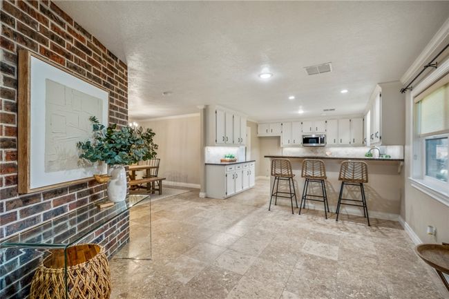 Kitchen featuring crown molding, visible vents, stainless steel microwave, a peninsula, and baseboards | Image 9