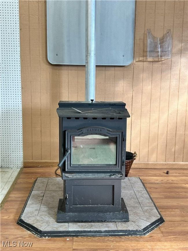 Room details with a pellett wood stove, and wooden walls | Image 8