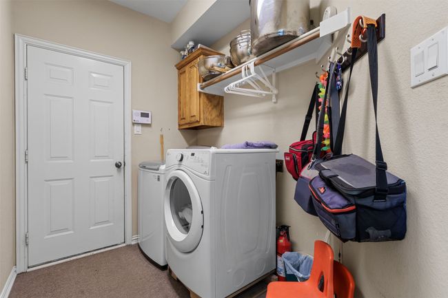Laundry area featuring washer and dryer, carpet, and cabinet space | Image 23