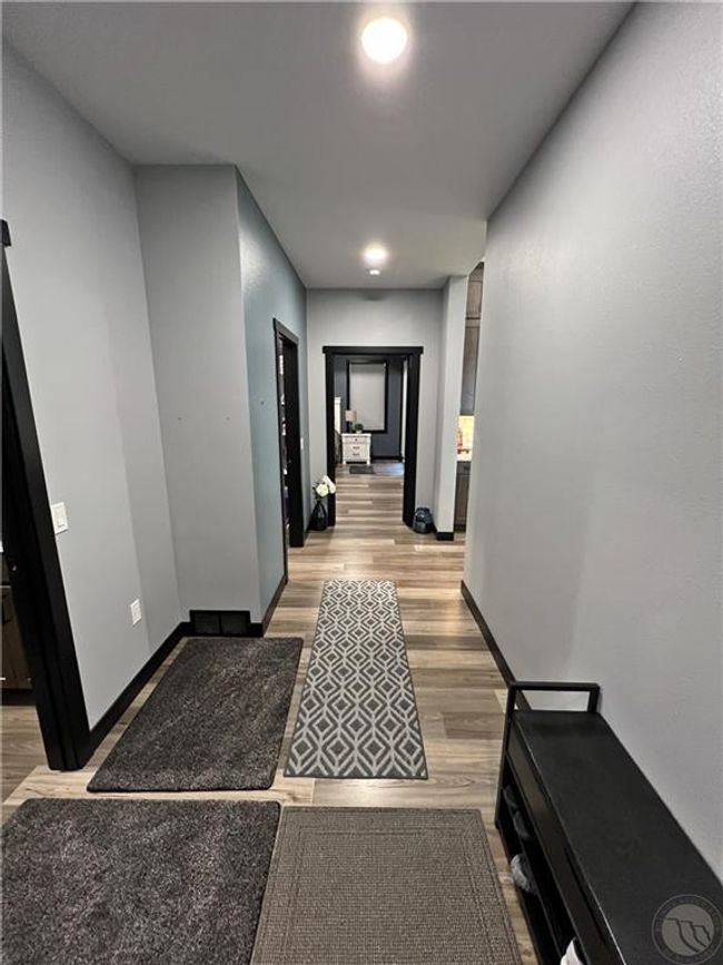 Hallway from garage facing the main bedroom suite.Pantry and laundry are on the left, and the stairs to the bonus suite are directly to the left. | Image 22