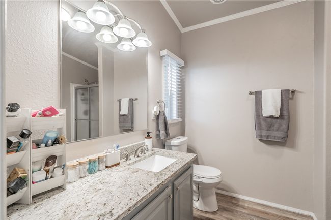 Full bathroom with crown molding, wood finished floors, a shower stall, and vanity | Image 20