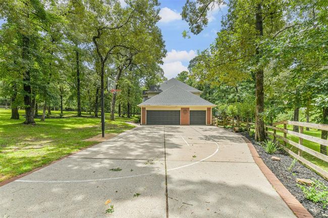 Spacious three-car garage with an oversized driveway for ample parking. | Image 48