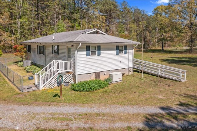 View of front of home with central air condition unit, crawl space, a front yard, and fence | Image 38