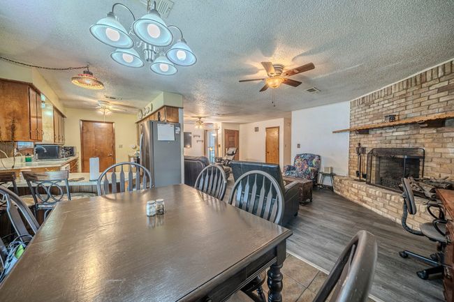 Dining space featuring ceiling fan, a fireplace, and a textured ceiling | Image 13