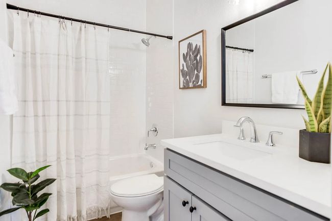 Full bathroom featuring toilet, vanity, and shower / tub combo with curtain | Image 4