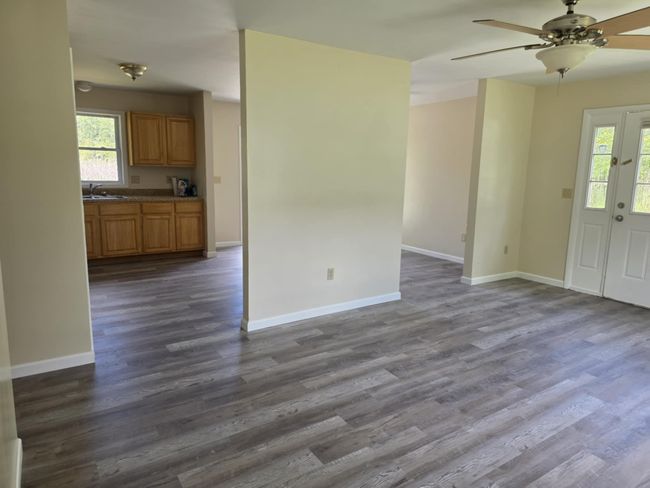 Unfurnished living room with healthy amount of natural light, dark wood finished floors, and a ceiling fan | Image 13