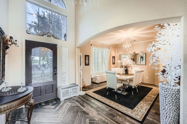 Foyer entrance with arched walkways, crown molding, and a chandelier | Image 4