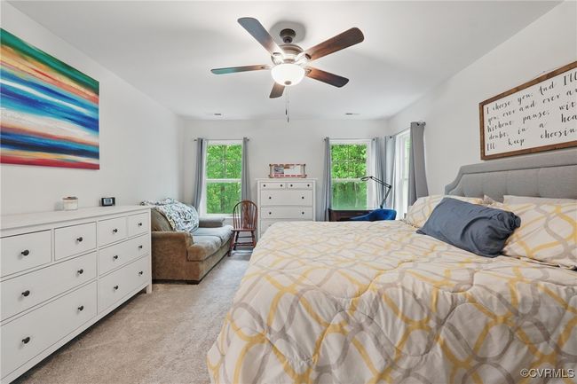 Expansive primary suite with ceiling fan and serene backyard views. | Image 16