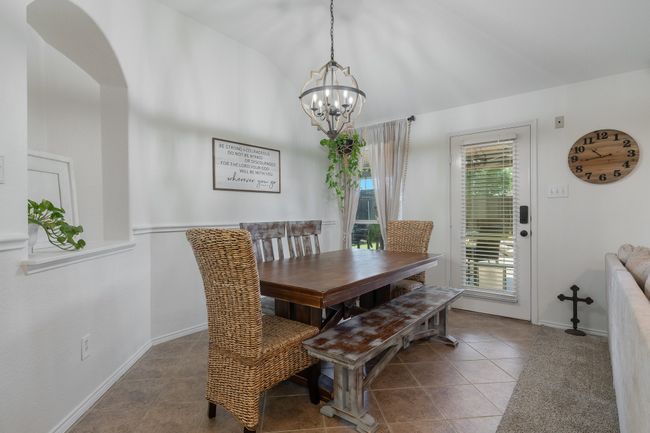 Tiled dining area featuring a chandelier, baseboards, vaulted ceiling, and arched walkways | Image 18
