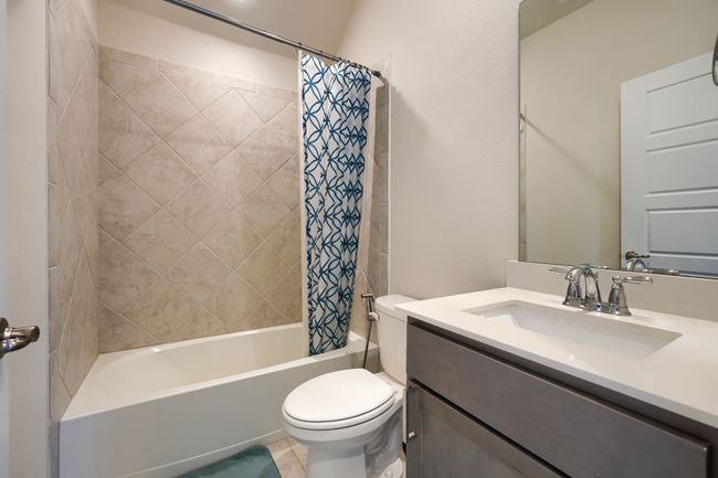 Full bathroom with toilet, vanity, and shower / bathtub combination with curtain | Image 27