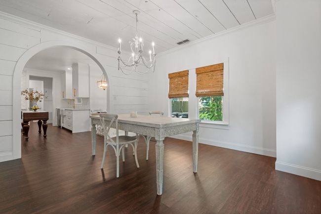 Dining space featuring a chandelier, arched walkways, dark wood-style floors, and ornamental molding | Image 9
