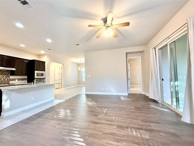 Kitchen featuring backsplash, light wood finished floors, a ceiling fan, recessed lighting, and stainless steel oven | Image 10