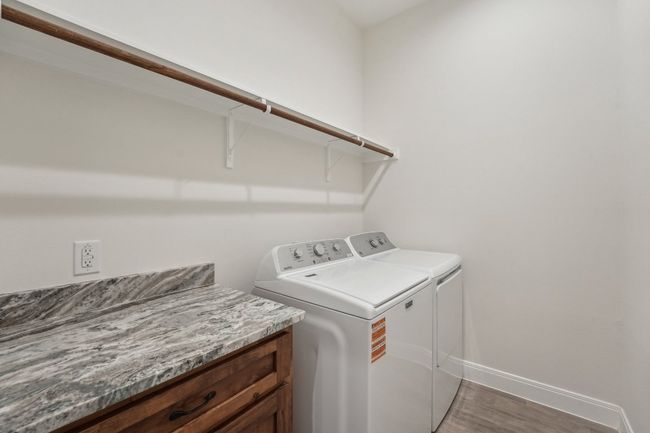 Clothes washing area with washer and dryer, baseboards, wood plank tile floor, and laundry area | Image 34
