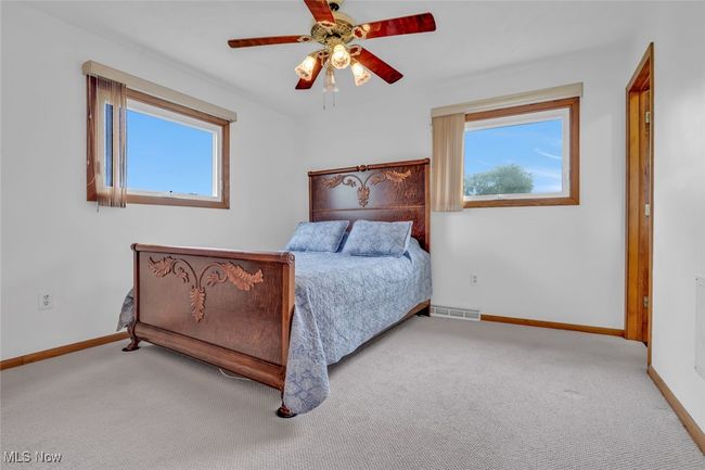 Carpeted bedroom featuring baseboards, multiple windows, and a ceiling fan | Image 18