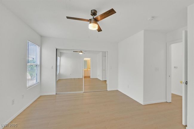 Unfurnished bedroom with light wood-type flooring, ceiling fan, and a closet | Image 10