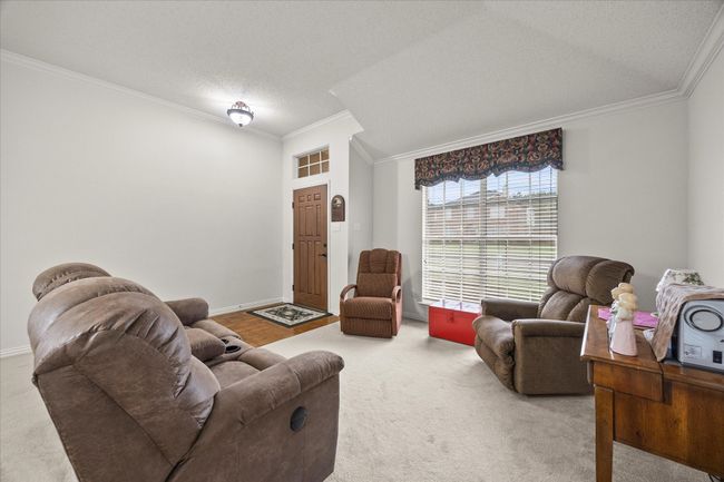Living room with carpet flooring, ornamental molding, and a textured ceiling | Image 8