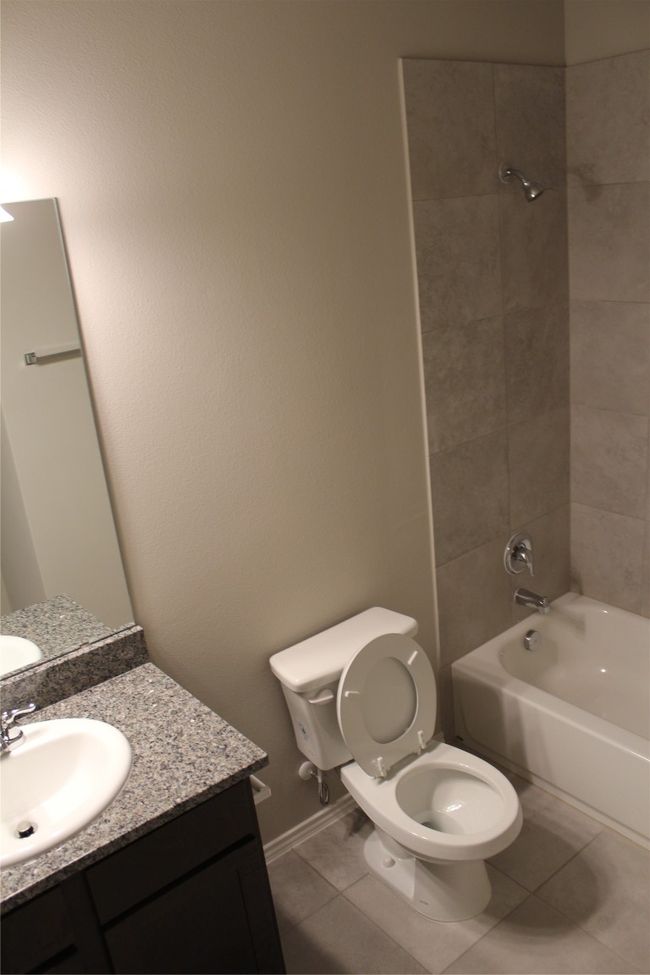 Bathroom featuring toilet, vanity, shower / bath combination, and tile patterned flooring | Image 18