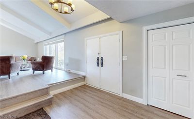 Entryway with a notable chandelier, vaulted ceiling with beams, and light hardwood / wood-style flooring | Image 2