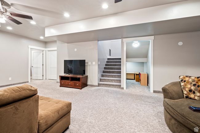 Carpeted living room with recessed lighting, stairway, baseboards, and ceiling fan | Image 39
