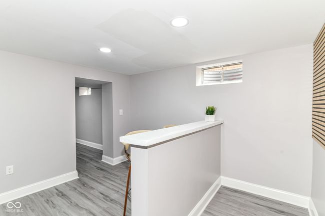 bar area featuring baseboards, light wood-type flooring, and recessed lighting | Image 27