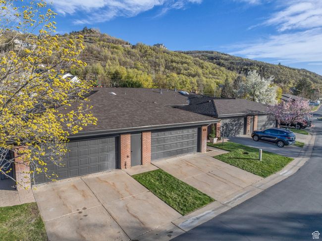 View of front of property featuring a mountain view, roof with shingles, concrete driveway, and brick siding | Image 38