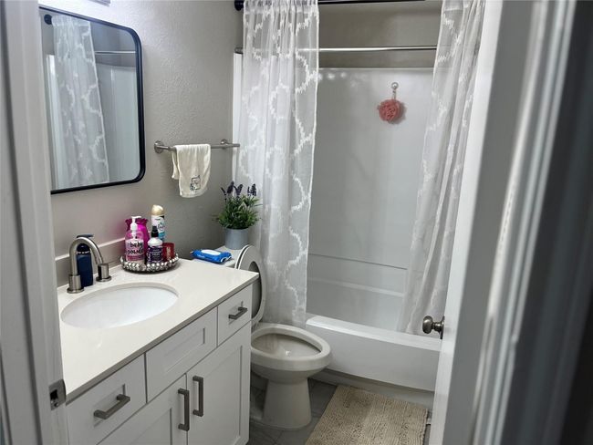 Full bathroom with tile patterned flooring, shower / bath combination with curtain, vanity, and toilet | Image 5