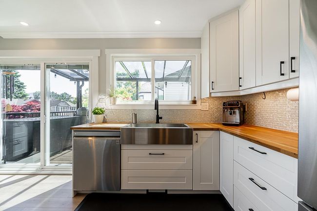 Kitchen featuring dishwasher, wooden counters, a sink, tasteful backsplash, and white cabinetry | Image 10