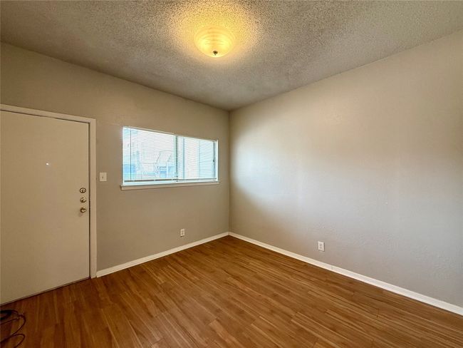 Spare room featuring wood finished floors and a textured ceiling | Image 8