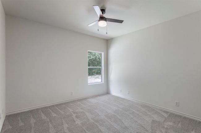 Carpeted spare room featuring ceiling fan and baseboards | Image 22