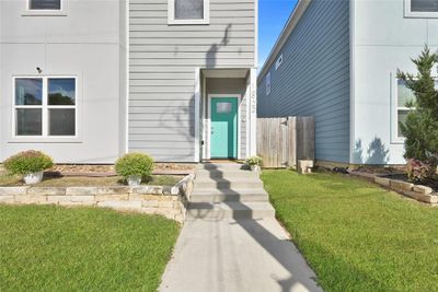 Your new front entrance has an elevated stucco & siding exterior that is accented by a striking teal door. | Image 2