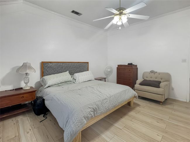 Bedroom featuring wood finished floors, ornamental molding, and ceiling fan | Image 7