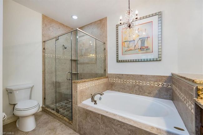 Bathroom featuring toilet, an inviting chandelier, and independent shower and bath | Image 15