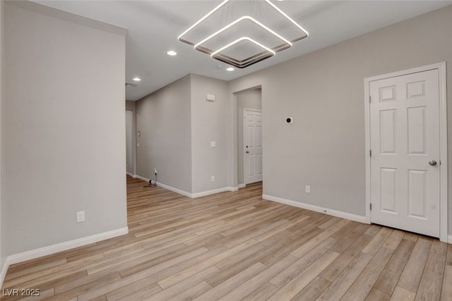 Spare room featuring a chandelier, light wood finished floors, recessed lighting, and baseboards | Image 8