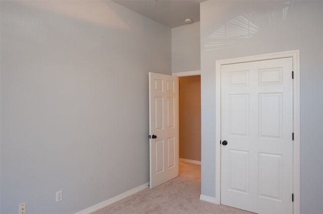 Unfurnished bedroom with light colored carpet and baseboards | Image 17