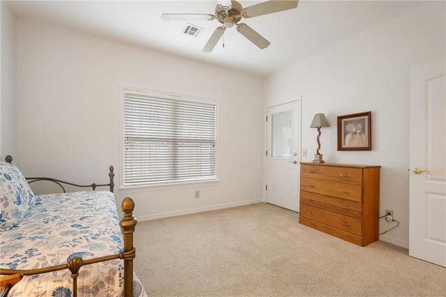 Bedroom with light colored carpet, baseboards, a ceiling fan, and visible vents | Image 40