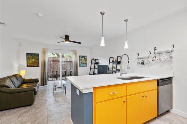 Kitchen with open floor plan, light marble finish floors, a peninsula, dishwasher, and light countertops | Image 7