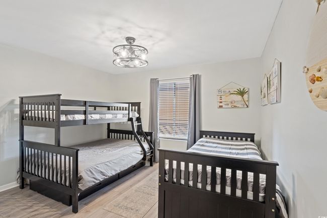 Bedroom with an inviting chandelier, baseboards, and wood finished floors | Image 19