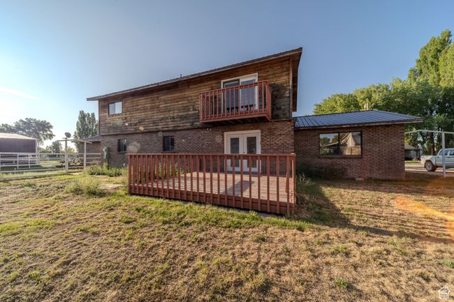 Back of house with fence, french doors, a lawn, brick siding, and metal roof | Image 4