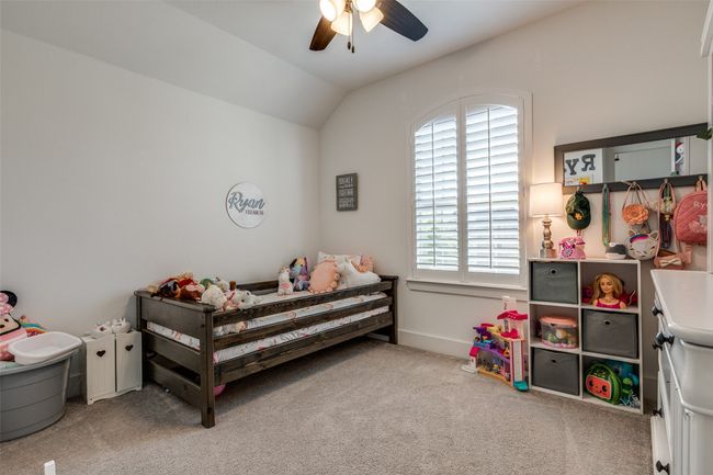 Bedroom featuring lofted ceiling, a ceiling fan, and carpet | Image 15