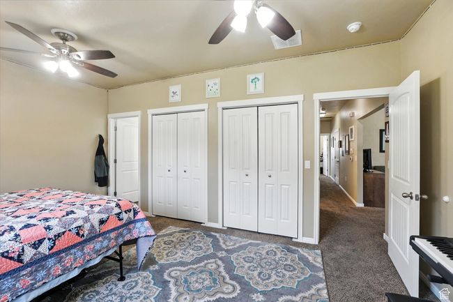 Bedroom featuring carpet floors, two closets, and a ceiling fan | Image 15