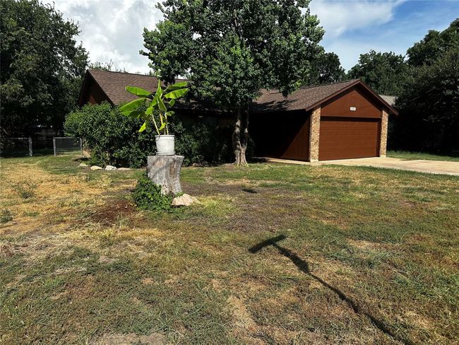 View of front facade with concrete driveway, a garage, and roof with shingles | Image 5