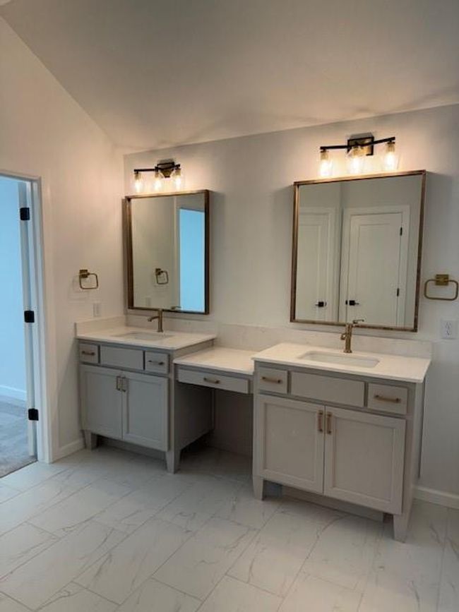 Bathroom featuring two vanities, baseboards, marble finish floor, and a sink | Image 26