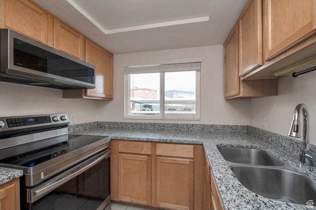Kitchen with stainless steel appliances and light stone counters | Image 6