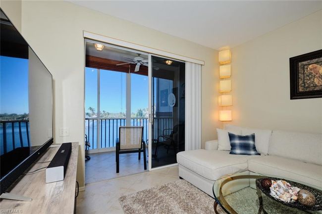 Living room with ceiling fan and a water view | Image 32