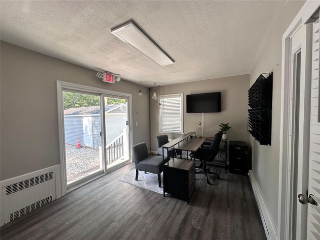 Office featuring radiator, wood finished floors, and a textured ceiling | Image 25