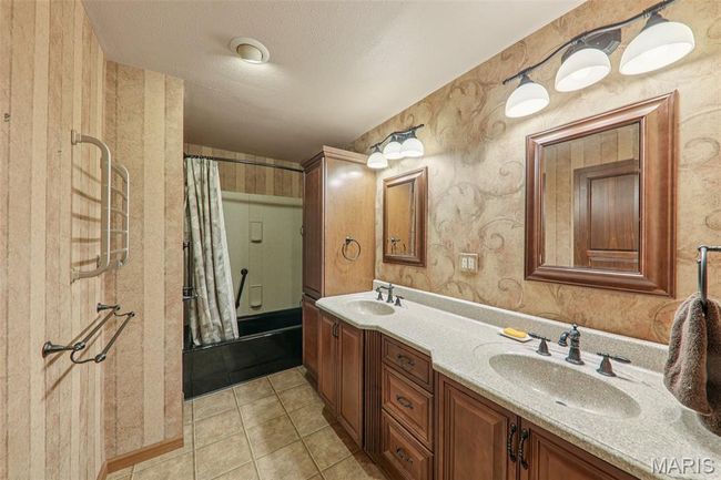 Bathroom featuring wallpapered walls, double vanity, tile patterned flooring, and shower / bath combo | Image 18