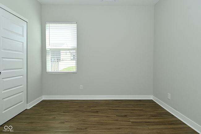 spare room with dark wood-style flooring, visible vents, and baseboards | Image 18