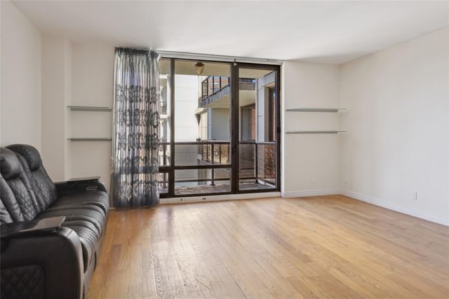 Unfurnished living room with expansive windows, baseboards, and light wood finished floors | Image 5