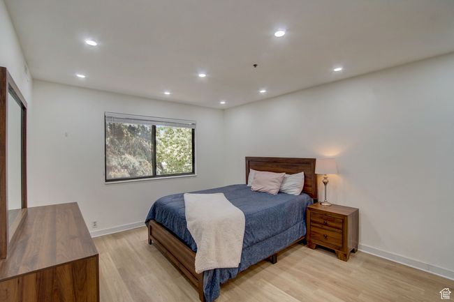 Bedroom with light wood-type flooring | Image 14